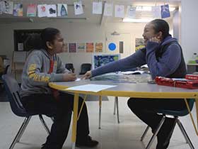 Teacher sitting at table with student photo