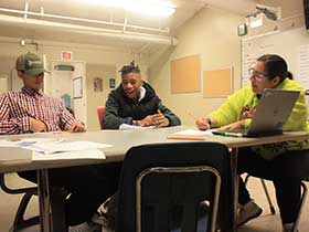 Teacher sitting at table with students photo